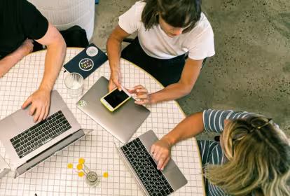 Dos mujeres y un hombre participan en una reunión 